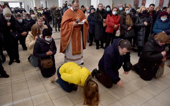 People pray for peace in Ukraine in front of the replica of the original statue of Our Lady of Fatima in the Church of the Nativity of the Blessed Virgin in Lviv, Ukraine, March 18, amid Russia's invasion of the country. (CNS/Reuters/Pavlo Palamarchuk)