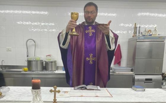 Archbishop Visvaldas Kulbokas, apostolic nuncio to Ukraine, elevates the Eucharist in the kitchen at the apostolic nunciature in Kyiv, Ukraine, in this recent photo. During the war, Archbishop Kulbokas has been celebrating Mass in the kitchen because it's