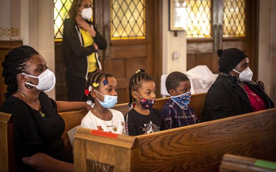 A family attends Mass at St. Barbara Catholic Church in Philadelphia Feb. 6. (CNS/Chaz Muth)