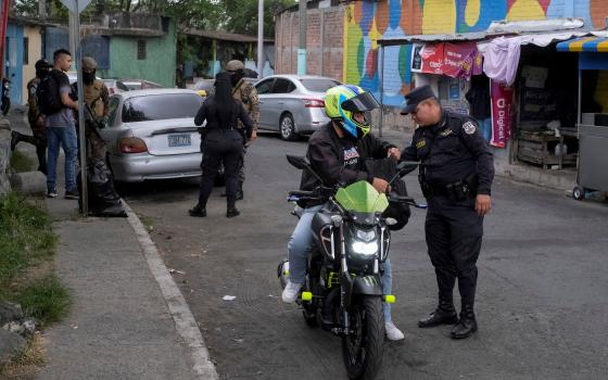 A Salvadoran police officer searches a man at a checkpoint in San Salvador March 30, 2022. (CNS photo/Jose Cabezas, Reuters)