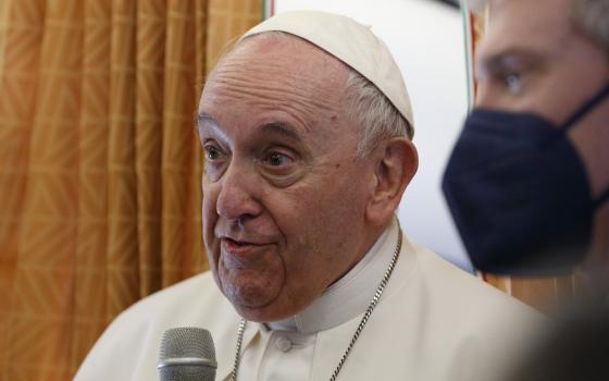 Pope Francis greets journalists aboard his flight from Rome to Malta April 2, 2022.