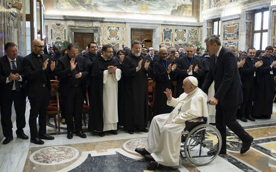 Pope Francis is pushed in a wheelchair by his aide, Sandro Mariotti, as he leaves an audience with students and professors of Rome's Pontifical Institute of Liturgy at St. Anselm, May 7 at the Vatican. (CNS/Vatican Media)