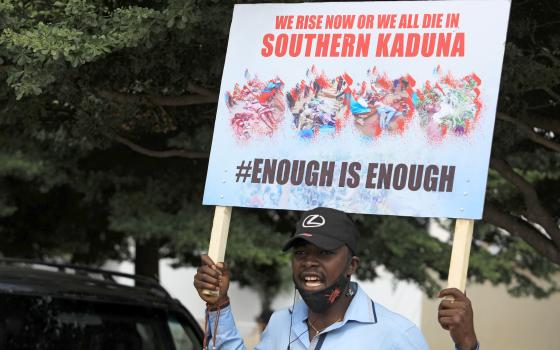 A man holds up a sign against killings in southern Kaduna state and insecurities in Nigeria during a protest in Abuja Aug. 15, 2020. (CNS photo/Afolabi Sotunde, Reuters)