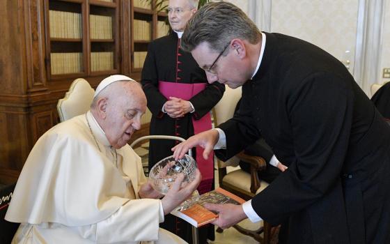 The Rev. Will Adam, deputy secretary-general of the Anglican Communion, presents a gift to Pope Francis during a meeting May 13, 2022. (CNS photo/Vatican Media)