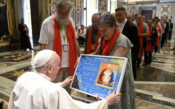 Pope Francis accepts a gift during an audience in the Vatican's Clementine Hall May 14, 2022. (CNS photo/Vatican Media)