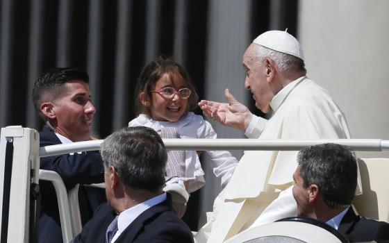 Pope Francis greets a child during his general audience in St. Peter's Square at the Vatican May 18, 2022. (CNS photo/Paul Haring)