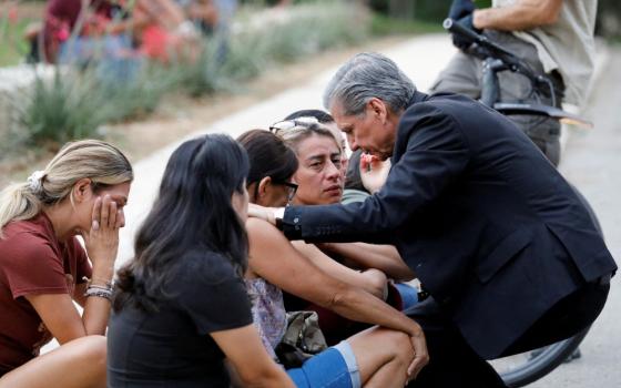 Archbishop Gustavo García-Siller of San Antonio comforts people outside the SSGT Willie de Leon Civic Center, where students had been transported from Robb Elementary School after a shooting, in Uvalde, Texas, May 24. (CNS/Reuters/Marco Bello)