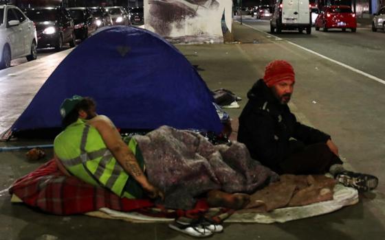 Homeless men sit along a street in São Paulo June 11, 2022. (CNS/Reuters/Amanda Perobelli)