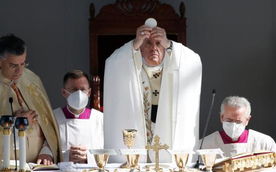 Pope Francis elevates the host as he celebrates Mass at the GSP Stadium in Nicosia, Cyprus, Dec. 3, 2021. (CNS/Paul Haring)