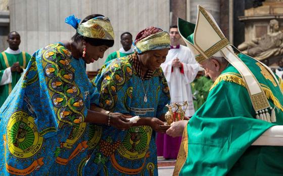 Two members of the Congolese community in Rome present the offertory gifts to Pope Francis during Mass in St. Peter's Basilica at the Vatican July 3. (CNS/Vatican Media)