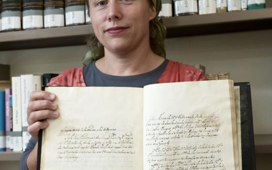 Pnina Younger, archivist at Central Archives for the History of the Jewish People at the Israel National Library, holds a rare 18th-century manuscript with details of the Portuguese Inquisition in Jerusalem July 19, 2022. (CNS photo/Debbie Hill)