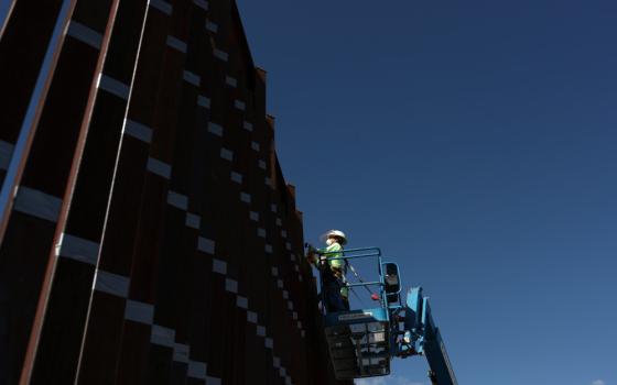 Contractors in Nogales, Ariz., prepare to paint the wall along the U.S.-Mexico border Sept. 13, 2018. (CNS photo/Adrees Latif, Reuters)