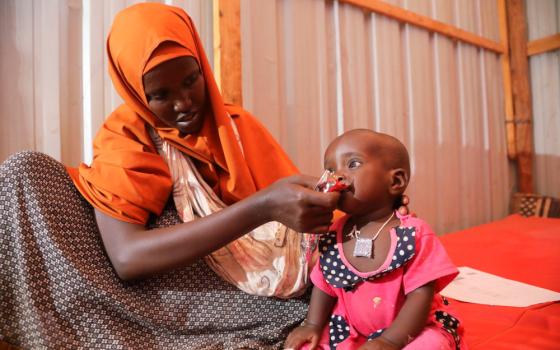 A displaced Somali woman feeds her child in a shelter during a severe drought near Dollow May 26. (CNS/Reuters/Feisal Omar)