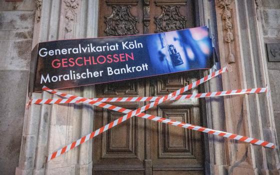 A banner with the inscription "Generalvikariat Köln — Geschlossen — Moralischer Bankrott" ("Vicar General's office Cologne CLOSED. Moral bankruptcy") and barrier tape are pictured stretched over the archdiocesan office in Cologne, Germany, Aug. 15.