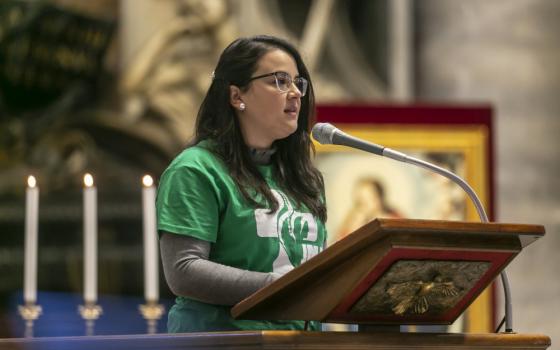 A young woman reads during Pope Francis' celebration of Mass on the feast of Christ the King in St. Peter's Basilica at the Vatican Nov. 22, 2020.