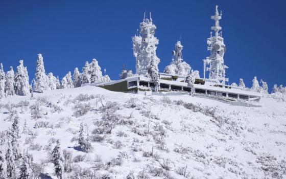 Snow-covered building pictured in snow-filled area.