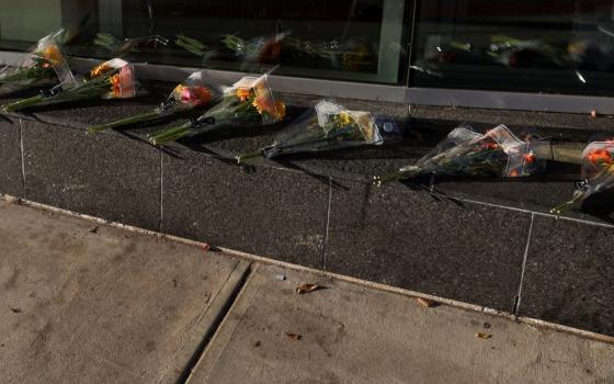 Bouquets of flowers lie on the ground at entrance of medical center.