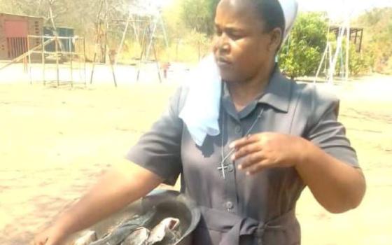 Woman holds a large bowl with fish.