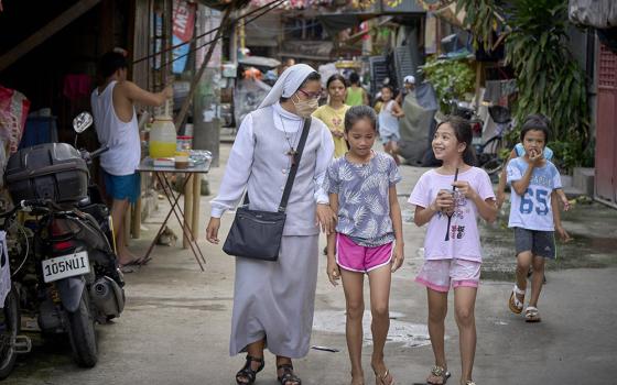 Sr. Mitzy Pérez, a member of the Missionary Sisters Servants of the Word from San Luis Potosi, Mexico, walks in a poor neighborhood of Kalookan, Philippines, Oct. 17, 2022. The diocese has established a mission station there to extend the outreach of the church to poor neighborhoods unreached by traditional parish structures. (CNS/Paul Jeffrey)