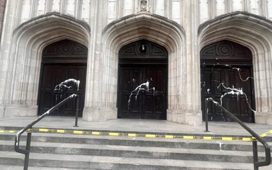 White paint is splattered across three wooden double doors at the top of stairs