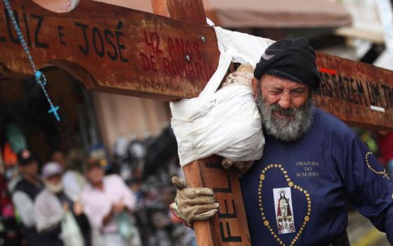 A worshipper carries a cross during the Good Friday procession in Pirapora do Bom Jesus, Brazil, on April 7, 2023. 