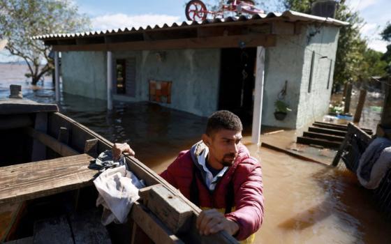 Valderci Trindade, 24, who lost his house, tries to save useful items May 14, 2024, in an area flooded by heavy rains in the Serraria neighborhood of Porto Alegr in Brazil's Rio Grande do Sul state. (OSV News photo/Diego Vara, Reuters)