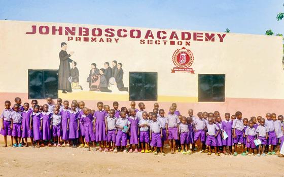 Elementary school pupils of John Bosco Academy, formerly St. Peter's Catholic School, in Ogoja, Cross River State, Nigeria, pose for a photo with Fr. Peter Abue, founder of the Children of Rural Africa initiative. (Valentine Benjamin)