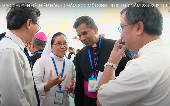 Msgr. Indunil Janakaratne Kodithuwakku Kankanamalage (in black) talks with participants at the gathering on May 23 in Ho Chi Minh City. (Screenshot/Joachim Pham/hdgmvietnam.com)