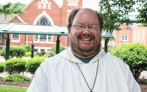 Brother Matson pictured smiling in front of a church building. 