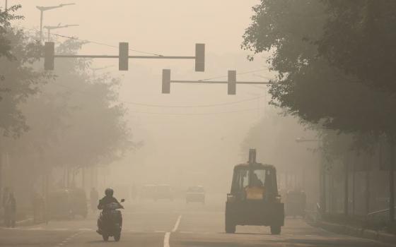 A motorcycle and bulldozer are seen on a smoggy morning in New Delhi, Nov. 17, 2023. Pollution and other environmental disasters attributed to climate change are the focus of delegates to the United Nations Climate Change Conference, known as COP28, being held Nov. 30 to Dec. 12 in Dubai, United Arab Emirates. (OSV News/Reuters/Anushree Fadnavis)