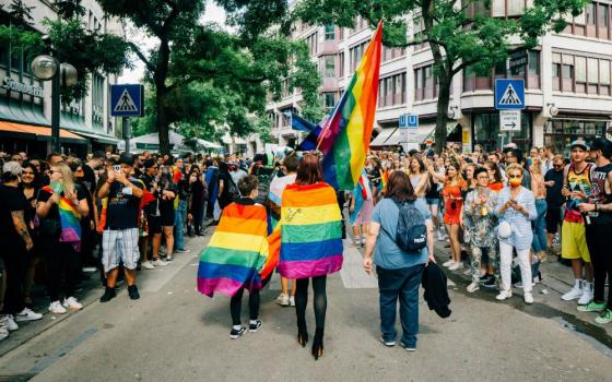 Women wrapped in rainbow flags