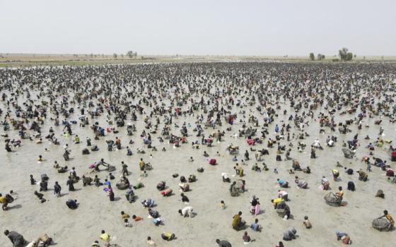 Wide view of a desiccated pond filled with people