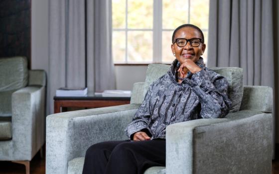 Pumla Gobodo-Madikizela sits in a chair smiling at camera