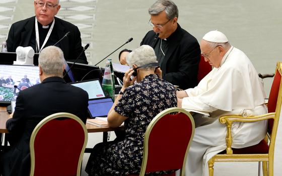 Pope Francis and leaders of the assembly of the Synod of Bishops listen to a speaker in the Vatican's Paul VI Audience Hall on Oct. 13, 2023. (CNS photo/Lola Gomez)