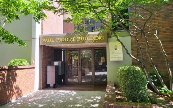 Entrance to building framed by tree. 