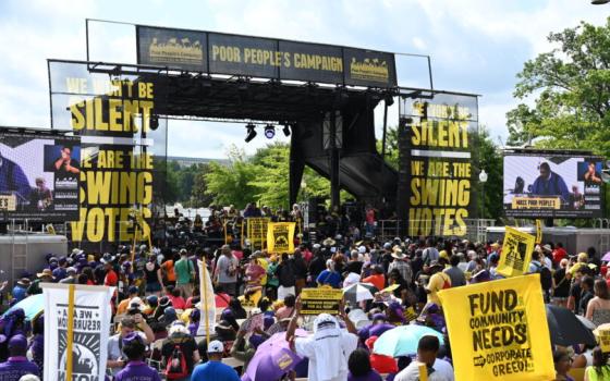 Large assemble holding sign, and a large platform bearing banners that read "the silent swing vote". 