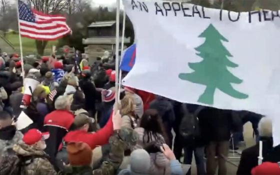 Swarming group holds various flags including "An Appeal to Heaven."