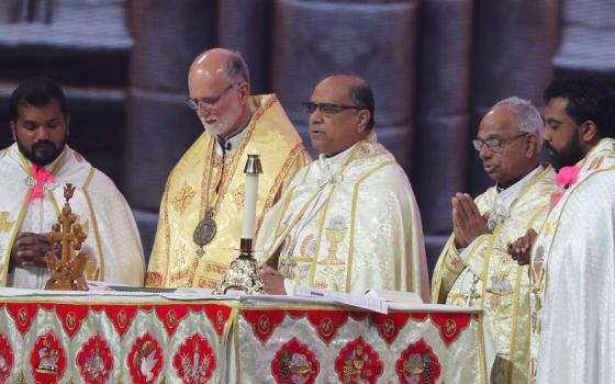 Bishops and other clergy stand around altar during liturgy; all vested. 