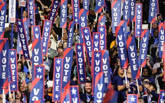 Delegates hold signs as former President Barack Obama speaks during the Democratic National Convention Aug. 20 in Chicago. (AP/Brynn Anderson)