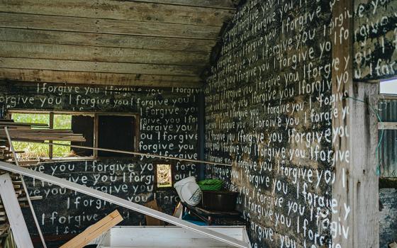 An abandoned room painted with I forgive you in white paint (Unsplash/Bailey Burton)