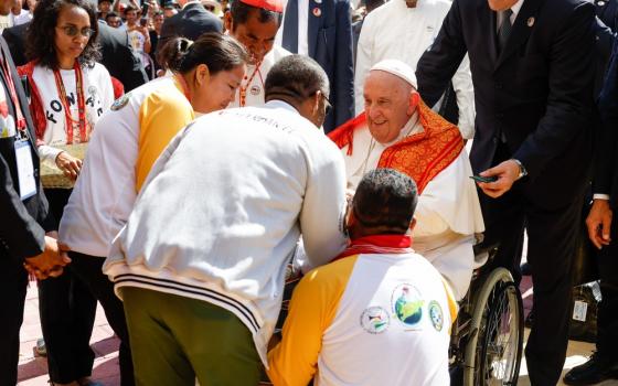 Francis in wheelchair greets people.