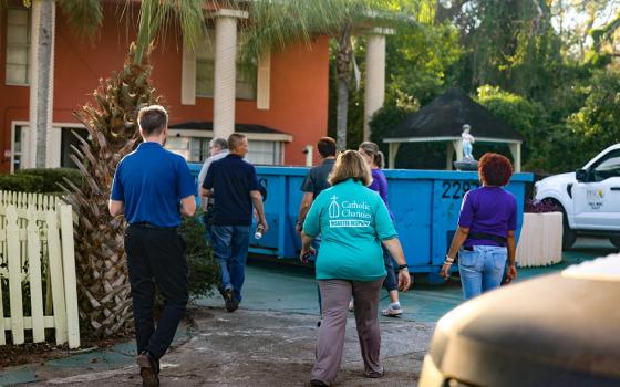 Kim Burgo, center, vice president of disaster operations at Catholic Charities USA, assesses damage in Florida with staff from Catholic Charities of the St. Petersburg Diocese in the aftermath of Hurricane Helene. (Courtesy of Catholic Charities USA/Jeremy Mines)