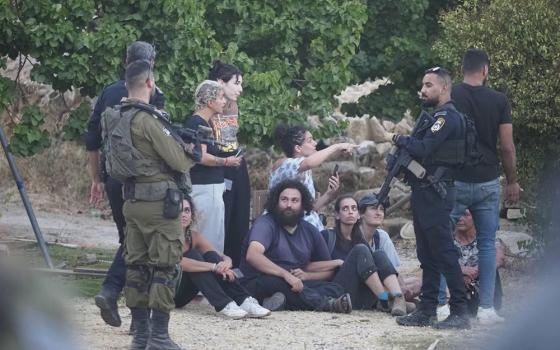 Amira Musallam, center, is surrounded by peacemakers protecting her on July 31 as she confronts representatives of the Israeli Defense Force, local police and Jewish settlers after the takeover of the home of her in-laws. (Courtesy of Amira Musallam)