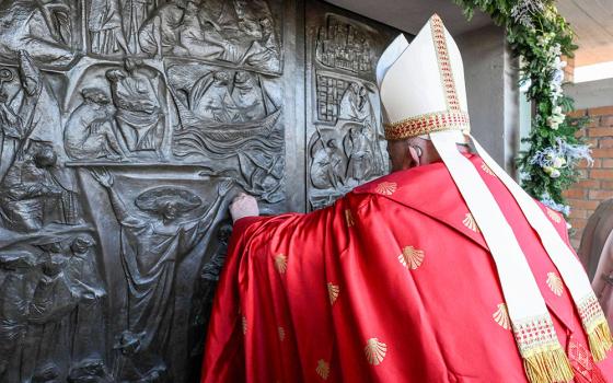 Pope Francis knocks on the Holy Door of the Church of Our Father at Rome's Rebibbia prison Dec. 26, 2024, before opening it and presiding over a Mass with inmates, prison staff and Italian government officials. (CNS/Vatican Media)