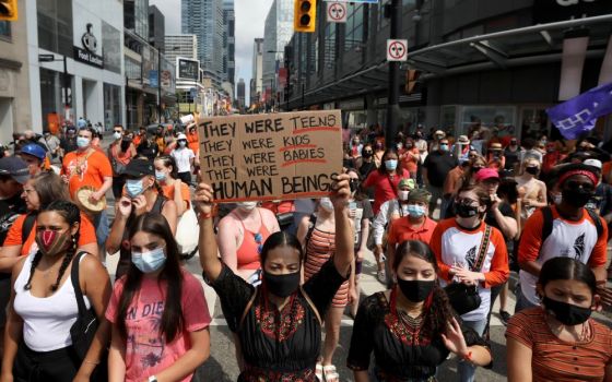 People march on Canada Day in Toronto July 1, 2021, after the discovery of hundreds of unmarked graves on the grounds of two former residential schools for Indigenous children in Canada. (CNS/Reuters/Carlos Osorio)