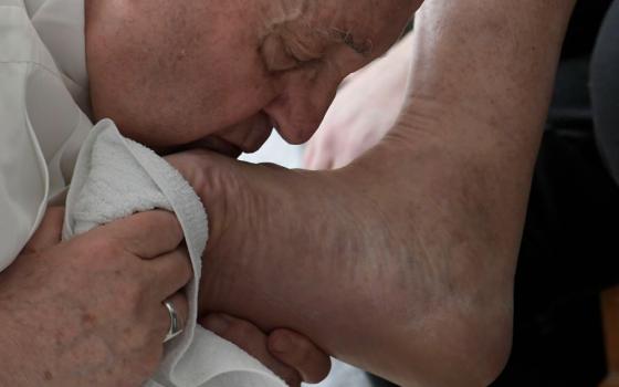 Pope Francis kisses the foot of an inmate after washing it during the Holy Thursday Mass of the Lord's Supper at a prison in Civitavecchia, Italy, April 14. (CNS/Vatican Media)