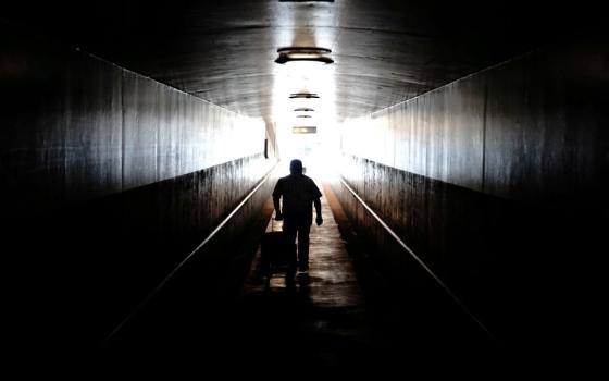 A traveler in Los Angeles pulls his rolling luggage behind him Aug. 10 as he walks toward a train platform at Union Station. The $1 trillion bipartisan infrastructure includes $66 billion in new funding for rail. (CNS/Reuters/Bing Guan)