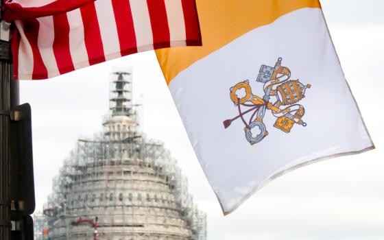 US flag, Vatican flag seen with US capitol dome in background with scaffolding