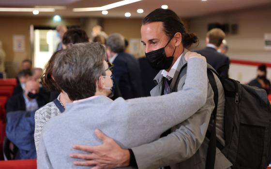 Olivier Savignac, right, one of the victims, greets an attendee during the publishing of a report by an independant commission into sexual abuse by church officials (Ciase), Tuesday, Oct. 5, 2021, in Paris. A major French report released Tuesday found tha