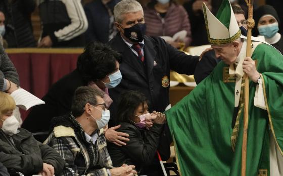 Pope Francis greets faithful at the end of a Mass on the Day of the Poor in St. Peter's Basilica, at the Vatican, Sunday, Nov. 14, 2021. (AP Photo/Gregorio Borgia)